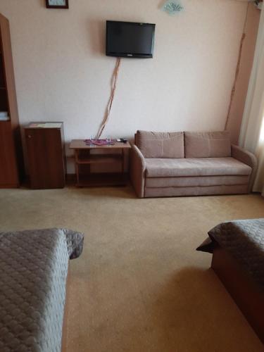 a living room filled with furniture and a tv at Stara Vezha Hotel in Boryspil