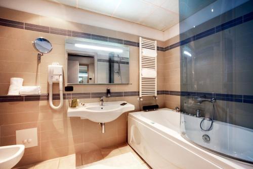 a bathroom with a sink and a bath tub and a sink at Cocca Hotel Royal Thai Spa in Sarnico