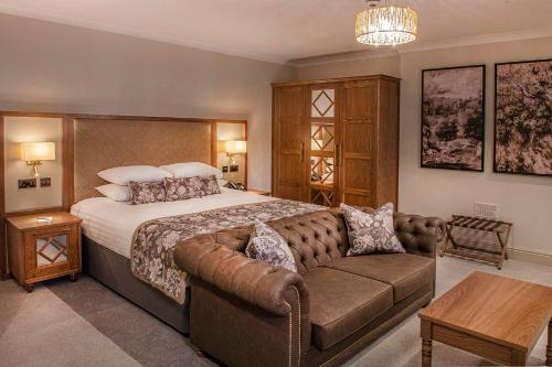 a bedroom with a large bed and a couch at De Vere Cranage Estate in Holmes Chapel