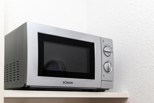 a microwave oven sitting on top of a shelf at BIT-City Studio und Appartement in Bitburg