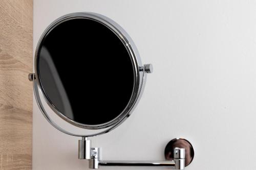 a round mirror on a white wall at BIT-City Studio und Appartement in Bitburg