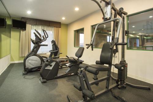 a gym with three exercise bikes in a room at Kalamazoo Hotel and Suites in Kalamazoo