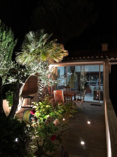 カップ・ダグドにあるCap d'Agde Naturist Hélio village 116の夜のパティオ(テーブル、ヤシの木付)