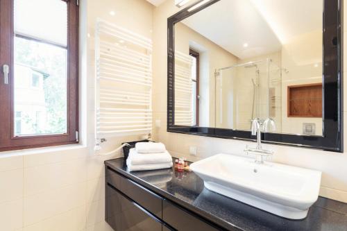 ein Bad mit einem Waschbecken und einem Spiegel in der Unterkunft Studio with terrace in a luxury closed estate by Grand Apartments in Sopot