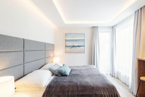 ein Schlafzimmer mit einem Bett und einem großen Fenster in der Unterkunft Studio with terrace in a luxury closed estate by Grand Apartments in Sopot