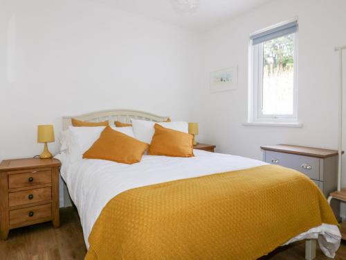 a bedroom with a large bed with a yellow blanket at Avalon in St. Agnes 