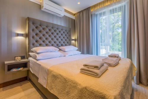 1 dormitorio con 1 cama grande y toallas. en BEACH FRONT VILLA FRAN - DELUXE PENTHOUSE SUITE with private pool, en Crikvenica