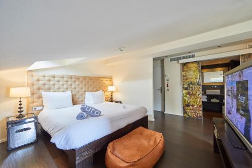 a bedroom with a large bed and a flat screen tv at Puro Hotel Oasis Urbano in Palma de Mallorca