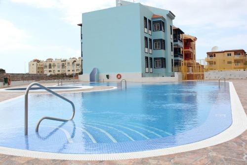 ein großes Schwimmbad vor einem Gebäude in der Unterkunft Perfecto apartamento de playa in Callao Salvaje