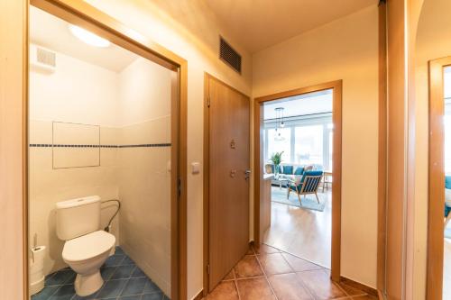 a bathroom with a toilet and a door to a room at apartmán Lípa in Liberec