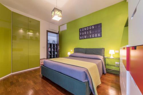 1 dormitorio con cama y pared verde en Pigneto & Malatesta Subway Flat, en Roma