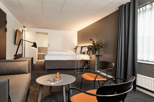 um quarto de hotel com uma cama, uma mesa e cadeiras em Comwell Kolding em Kolding