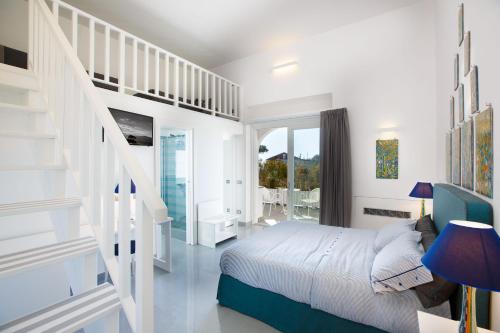 a white bedroom with a bed and a staircase at Casacolarusso in Massa Lubrense