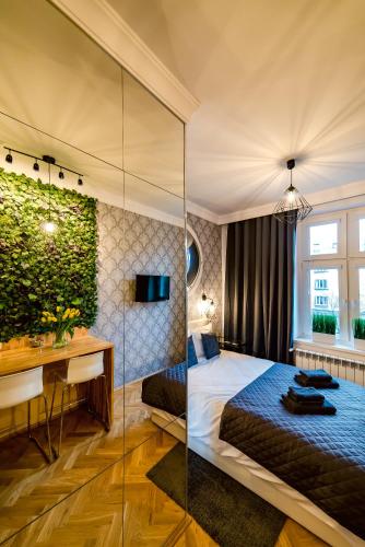 a hotel room with a bed and a desk and a room at Słowackiego Apartments in Krakow