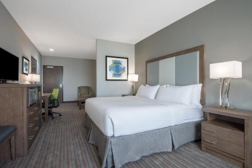 A bed or beds in a room at Holiday Inn Express & Suites Stillwater - University Area, an IHG Hotel