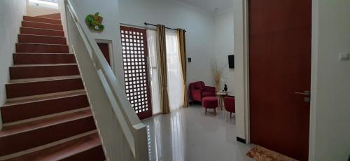 a hallway of a home with stairs and a red chair at VILLA BATU 3F in Batu