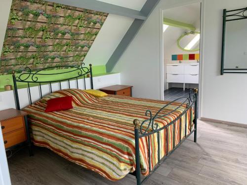 1 dormitorio con 1 cama con una manta colorida en Kerrouz, en Bannalec