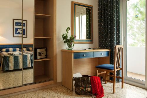 a bedroom with a desk and a mirror and a chair at Opción Roulette de Paya Hotels in Es Pujols