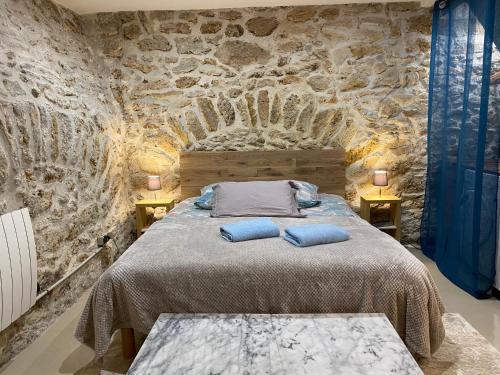 - une chambre aux murs en pierre dotée d'un lit avec des oreillers bleus dans l'établissement Large and unique souplex 60sqm, well located, à Paris