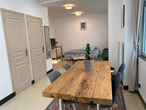 Cette chambre comprend une table et des chaises en bois ainsi qu'un lit. dans l'établissement Large and unique souplex 60sqm, well located, à Paris