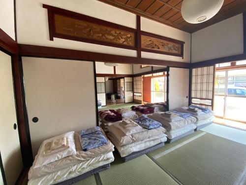 a room with four beds in a room at Traveler's Wharf Shichigahama in Shichigahama
