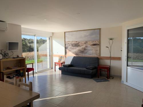 a living room with a blue couch and a table at Kerrouz in Bannalec