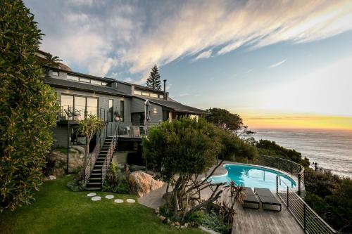 a house with a swimming pool next to the ocean at The Gekko Lodge in Cape Town