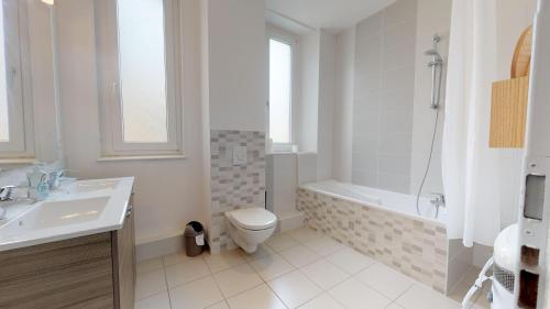 une salle de bain avec toilettes, baignoire et lavabo dans l'établissement L'Entêté CLIM HYPERCENTRE 5-7 personnes, à Colmar