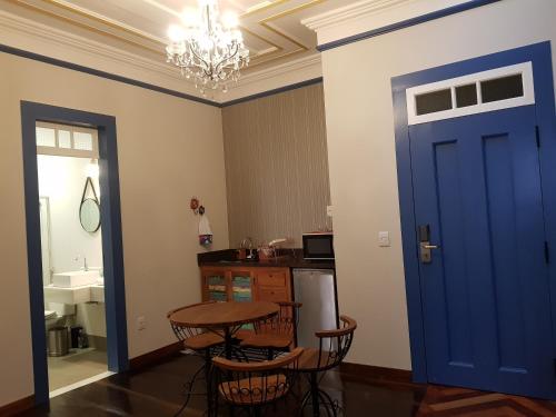 a room with a blue door and a table and chairs at Suite Família Inconfidentes in Ouro Preto