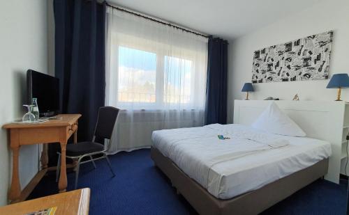 a hotel room with a bed and a desk and a computer at AKZENT Hotel Merfelder Hof in Dülmen