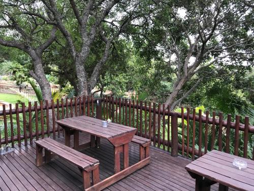 a picnic table and two benches on a wooden deck at Amafu Forest Lodge in Hoedspruit