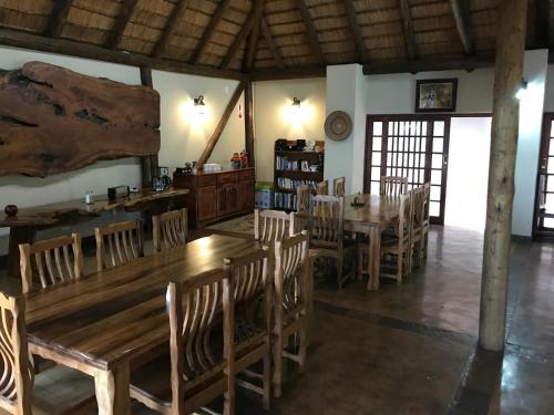 a dining room with wooden tables and chairs at Amafu Forest Lodge in Hoedspruit