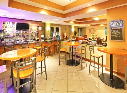 a restaurant with wooden tables and a bar at Hyatt House Bentonville Rogers in Rogers
