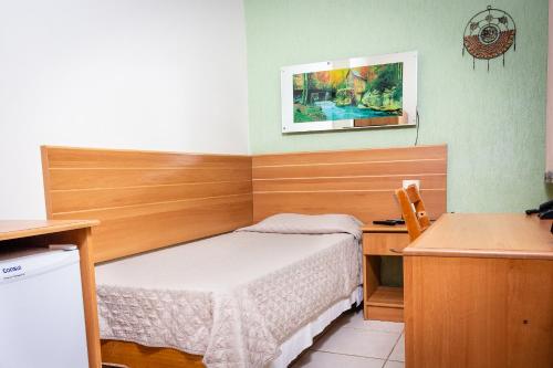 a small bedroom with a bed and a desk at Hotel Pousada Bonita - 150m Metrô Paraiso e 1Km do inicio Av Paulista in São Paulo