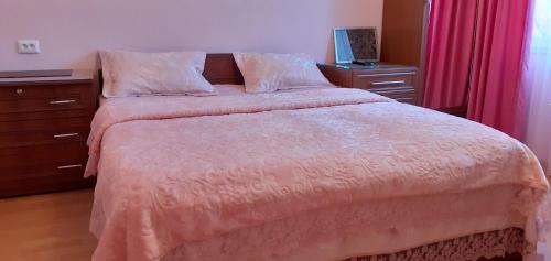 a bedroom with a bed with a pink bedspread at Guesthouse Next to beach in Batumi