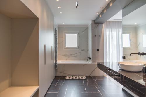 a bathroom with a large tub and a sink at PINACOTA SUITES ATHENS in Athens