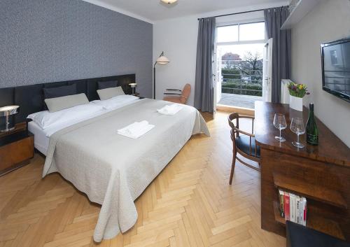 a bedroom with a bed and a table and a television at Bed&Breakfast & Apartment Klafé in Brno