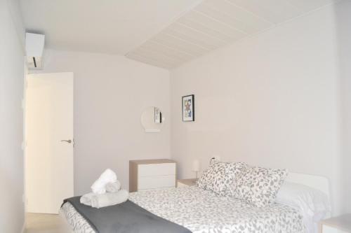 a white room with a bed and a couch at Apartamento El Monasterio in Toledo