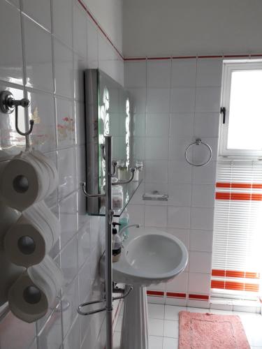 ein weißes Badezimmer mit einem Waschbecken und einem Spiegel in der Unterkunft Rafina K-Apartment in Rafina