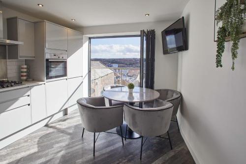 cocina con mesa, sillas y ventana en Host & Stay - The View, Hudsons Yard House, en Whitby