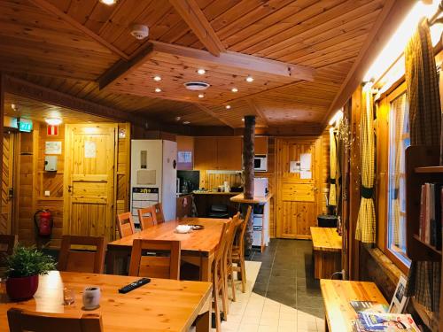 a kitchen and dining room with wooden tables and chairs at Hotelli Vuorikelo in Muurame