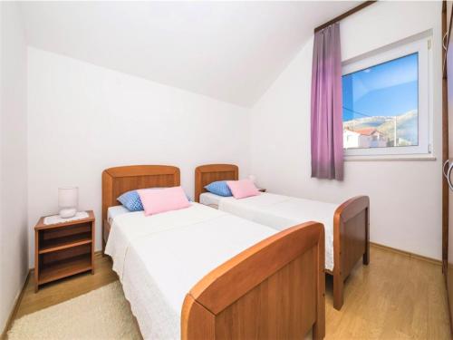 two beds in a room with a window at Apartment Sensa in Trogir