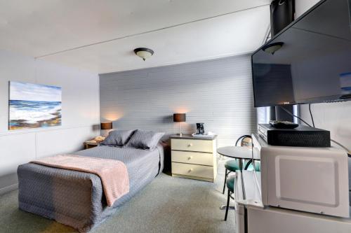 Saint-AntoninにあるMotel Expressの小さなベッドルーム(ベッド1台、テーブル付)