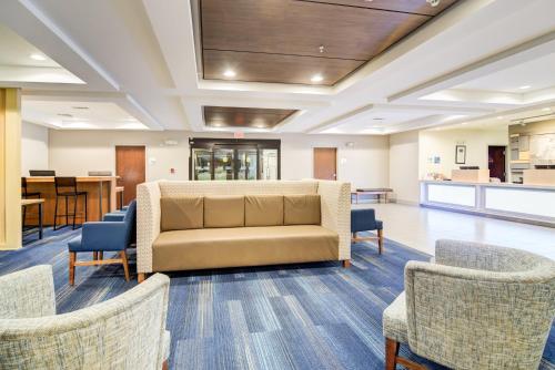 a waiting room with a couch and chairs at Holiday Inn Express Hotel & Suites Foley by IHG in Foley
