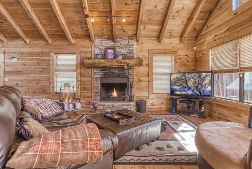 a living room with a fireplace in a log cabin at Always and Forever-Hot Tub, Arcade, Near the Parkway! in Pigeon Forge