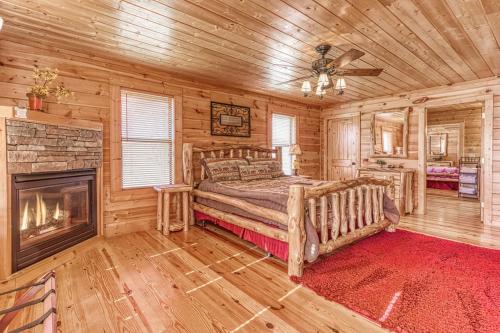 a bedroom with a bed and a fireplace in a log cabin at Always and Forever-Hot Tub, Arcade, Near the Parkway! in Pigeon Forge