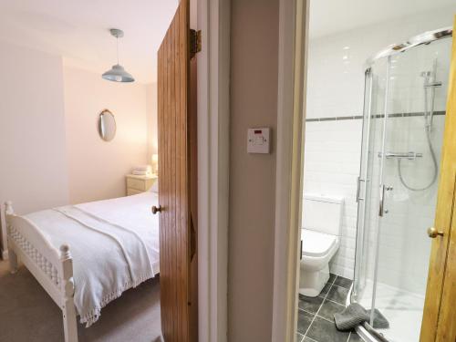 a bedroom with a bed and a shower and a toilet at 24 College Lane in Stratford-upon-Avon