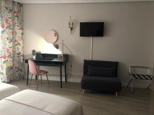 1 dormitorio con escritorio, silla y espejo en Hotel Marqués de Santillana en Torrelavega