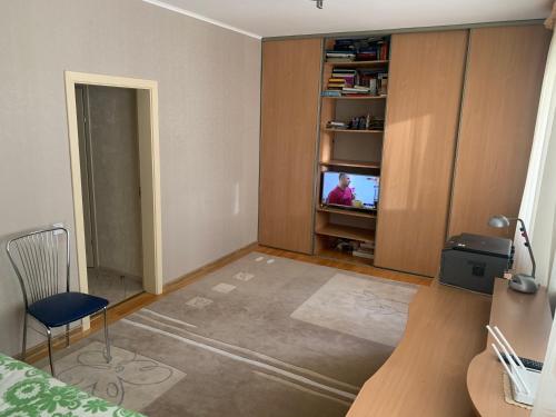 a living room with a television and a room with a couch at Bright room near International Exhibition Centre in Kyiv