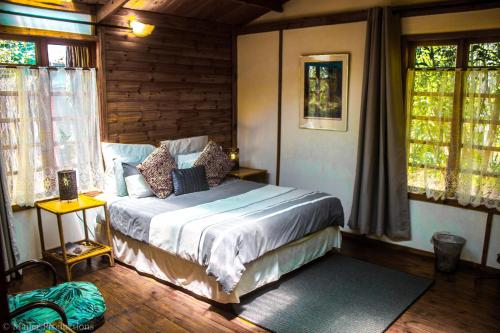 マガリスバーグにあるWoodland Gardens Pet Friendly Lodgeの窓付きの部屋にベッド付きのベッドルーム1室があります。